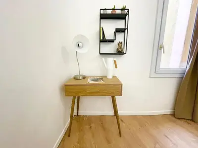 a table with a lamp and a mirror on a wall at T2 Cosy - Place des Cardeurs in Aix-en-Provence