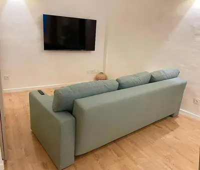 a green couch in a living room with a flat screen tv at T2 Cosy - Place des Cardeurs in Aix-en-Provence
