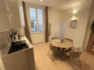 a kitchen with a table and chairs in a room at T2 Cosy - Place des Cardeurs in Aix-en-Provence