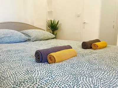 a bed with three towels on top of it at T2 Cosy - Place des Cardeurs in Aix-en-Provence