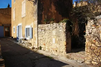 an old stone wall next to a building at gîte à Rustrel in Rustrel