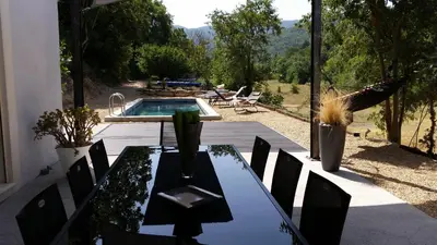 a patio with a table and a swimming pool at Menerbes Luberon maison moderne clim piscine in Ménerbes
