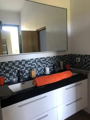 a bathroom with a large mirror and a sink at Menerbes Luberon maison moderne clim piscine in Ménerbes