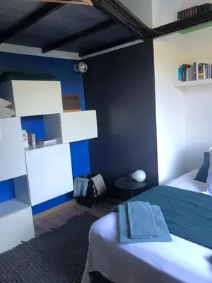 a bedroom with two beds and a blue wall at Menerbes Luberon maison moderne clim piscine in Ménerbes