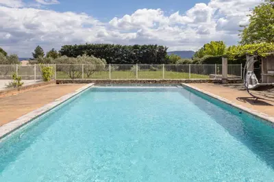 a swimming pool with blue water in a yard at Le Petit Nid in Saint-Rémy-de-Provence