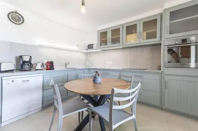 a kitchen with a wooden table and chairs at Le Petit Nid in Saint-Rémy-de-Provence