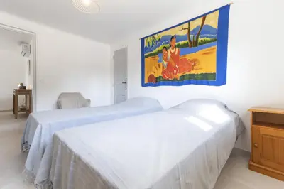 a room with two beds and a painting on the wall at Le Petit Nid in Saint-Rémy-de-Provence