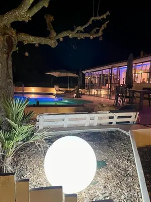 a view of a pool at night with lights at L'Apt Tropez in Apt