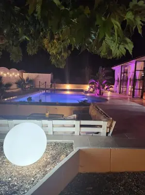 a swimming pool at night with two lights at L'Apt Tropez in Apt