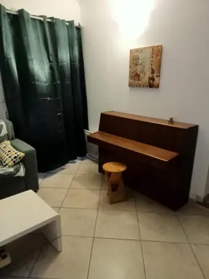 a bathroom with a wooden bench and a green shower curtain at petite maison avec jardin calme in Le Thor