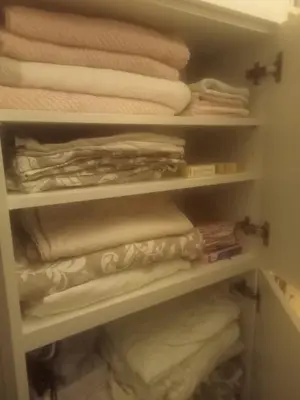 a closet filled with white towels and towels at petite maison avec jardin calme in Le Thor