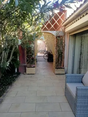 a walkway leading to a house with a patio at petite maison avec jardin calme in Le Thor
