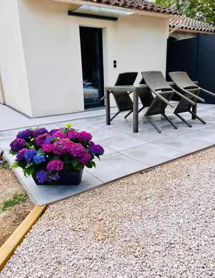a patio with a table and chairs and purple flowers at La Villa Rustica in Aix-en-Provence