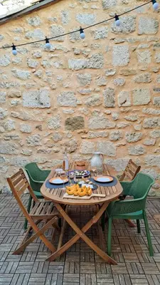 a wooden table with fruit on it in front of a stone wall at Charming & medieval village house completely renovated with great exterior and views in Mallemort
