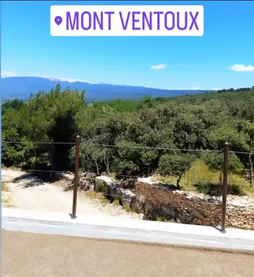 a view of the mountains from a mountain view from a fence at Là où le Ciel est né Beau mas pierres et contemporain sur grande propriété vue Mont Ventoux dentelles de Montmirail in Blauvac