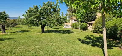 a field with trees and a house in the background at La Bastide des Muriers in Gargas