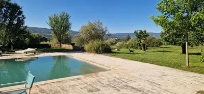 a swimming pool in a yard with a field and trees at La Bastide des Muriers in Gargas