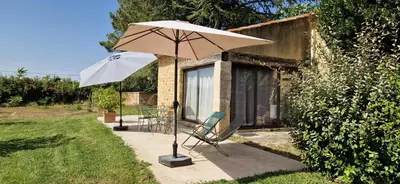 a patio with a chair and an umbrella at La Bastide des Muriers in Gargas