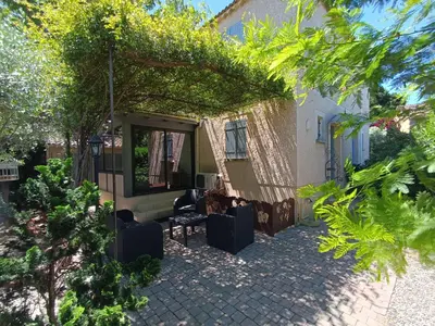 a patio of a house with chairs and trees at Maison provençale avec piscine partagée in Loriol-du-Comtat