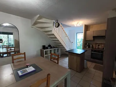 a kitchen and dining room with a spiral staircase at Maison provençale avec piscine partagée in Loriol-du-Comtat