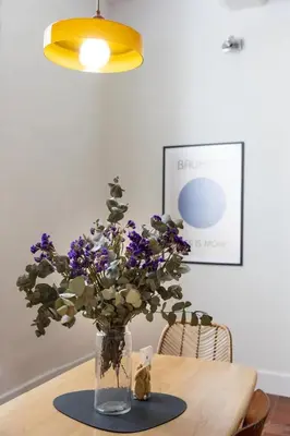 a vase with purple flowers sitting on a table at Mistral126 in Aix-en-Provence