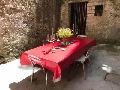 a red table with candles and flowers on it at La Maison Joly in Ménerbes