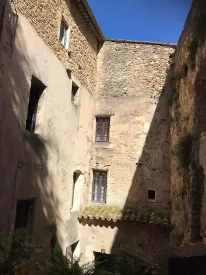 an old stone building with windows on the side of it at La Maison Joly in Ménerbes
