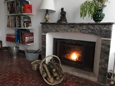 a fireplace in a living room with a fire in it at La Maison Joly in Ménerbes