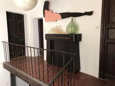 a fireplace in a room with a vase on the wall at La Maison Joly in Ménerbes