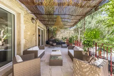 an outdoor patio with wicker chairs and a table at Oasis de Gordes in Gordes