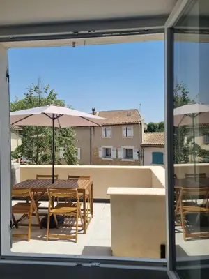 a view of a patio with tables and umbrellas at Maison de village avec terrasse in Grans