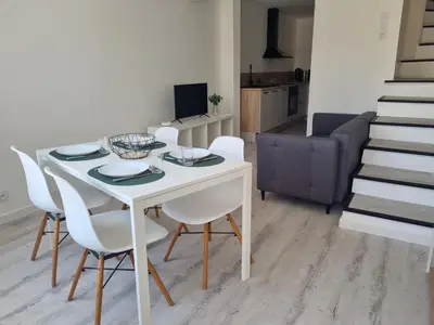 a dining room with a white table and white chairs at Maison de village avec terrasse in Grans