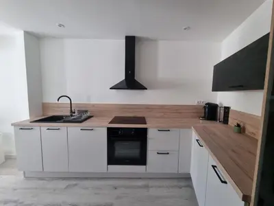 a kitchen with white cabinets and a sink and a stove at Maison de village avec terrasse in Grans