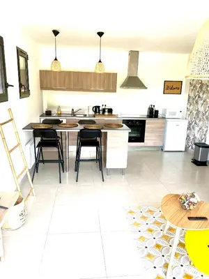a kitchen with a table and some chairs in it at Le jardin de Vaumartin in Meyrargues