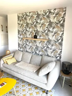 a living room with a couch in front of a wall at Le jardin de Vaumartin in Meyrargues