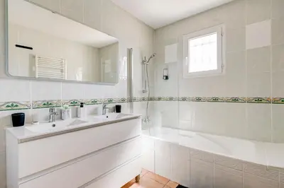 a white bathroom with a tub and a sink at Les Hauts de Provence - Maison avec piscine in Aix-en-Provence