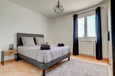 a bedroom with a bed and a large window at Les Hauts de Provence - Maison avec piscine in Aix-en-Provence