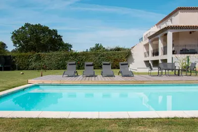 a swimming pool with lounge chairs and a house at Les Hauts de Provence - Maison avec piscine in Aix-en-Provence