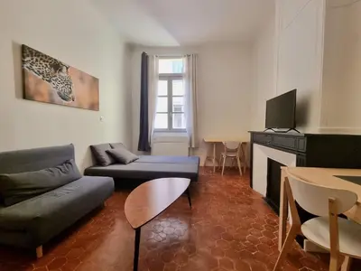 a living room with a couch and a tv at Studio centre historique 2 in Aix-en-Provence