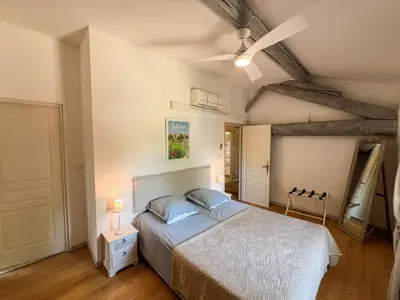 a bedroom with a bed and a ceiling fan at Mazet des Balestiés cœur Luberon 120 m2 6 pers avec piscine in Gargas