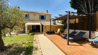 a backyard with a wooden deck and a house at Mazet des Balestiés cœur Luberon 120 m2 6 pers avec piscine in Gargas