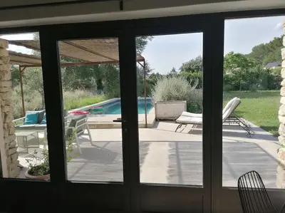 a sliding glass door with a view of a pool at Le Mazet d'Alexis in Maubec