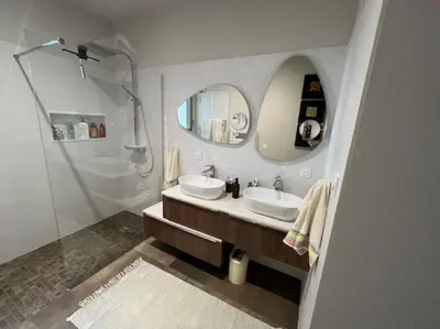 a bathroom with two sinks and a shower and a mirror at Belle contemporaine avec piscine proche d'Aix en Provence in Rognes