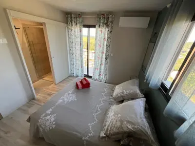 a bedroom with a bed with a red bag on it at Belle contemporaine avec piscine proche d'Aix en Provence in Rognes