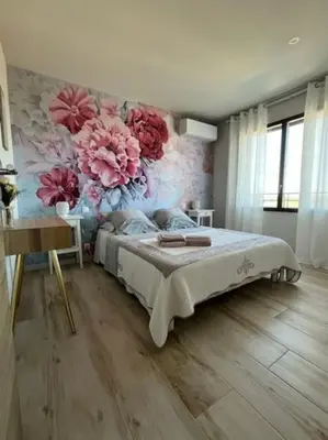 a bedroom with a bed with a floral wall at Belle contemporaine avec piscine proche d'Aix en Provence in Rognes