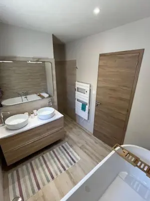 a bathroom with two sinks and a mirror and a tub at Belle contemporaine avec piscine proche d'Aix en Provence in Rognes