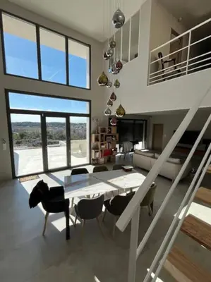 a dining room with a table and chairs in a room at Belle contemporaine avec piscine proche d'Aix en Provence in Rognes