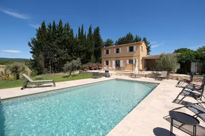 a large swimming pool with chairs and a house at Air-conditioned villa with private pool overlooking Roussillon - Luberon - 8 people. in Roussillon
