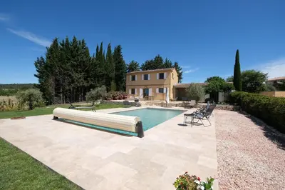 a swimming pool in front of a house at Air-conditioned villa with private pool overlooking Roussillon - Luberon - 8 people. in Roussillon