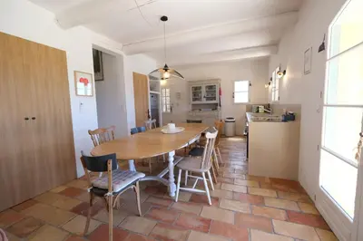 a kitchen and dining room with a wooden table and chairs at Air-conditioned villa with private pool overlooking Roussillon - Luberon - 8 people. in Roussillon
